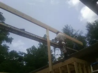Carpenter setting a ridge beam over a new addition frame — Ice Dam Removal by Roofing Brothers in Gaffney