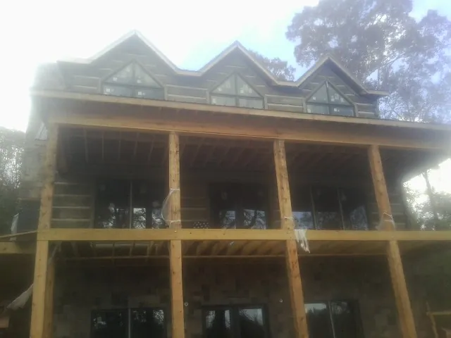 Dormers and porch framing on a large log home under construction — Roof Coating work by our crew in Gaffney