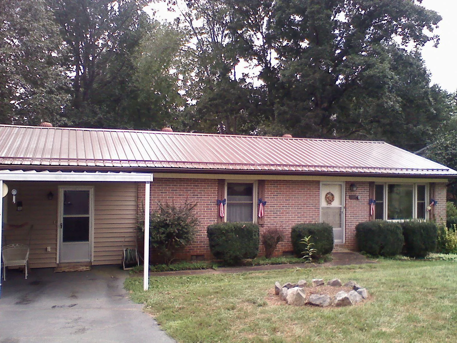 Bronze metal roof and carport on a brick ranch home — Roof Repair work by our crew in Gaffney