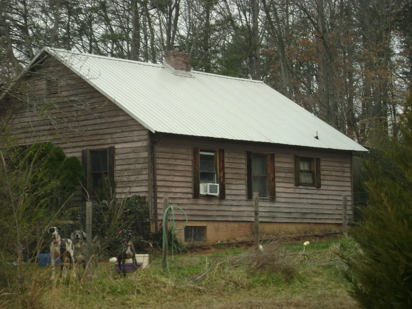 White metal roof on an old wood sided farmhouse, from a Metal Roof Installation job in Gaffney